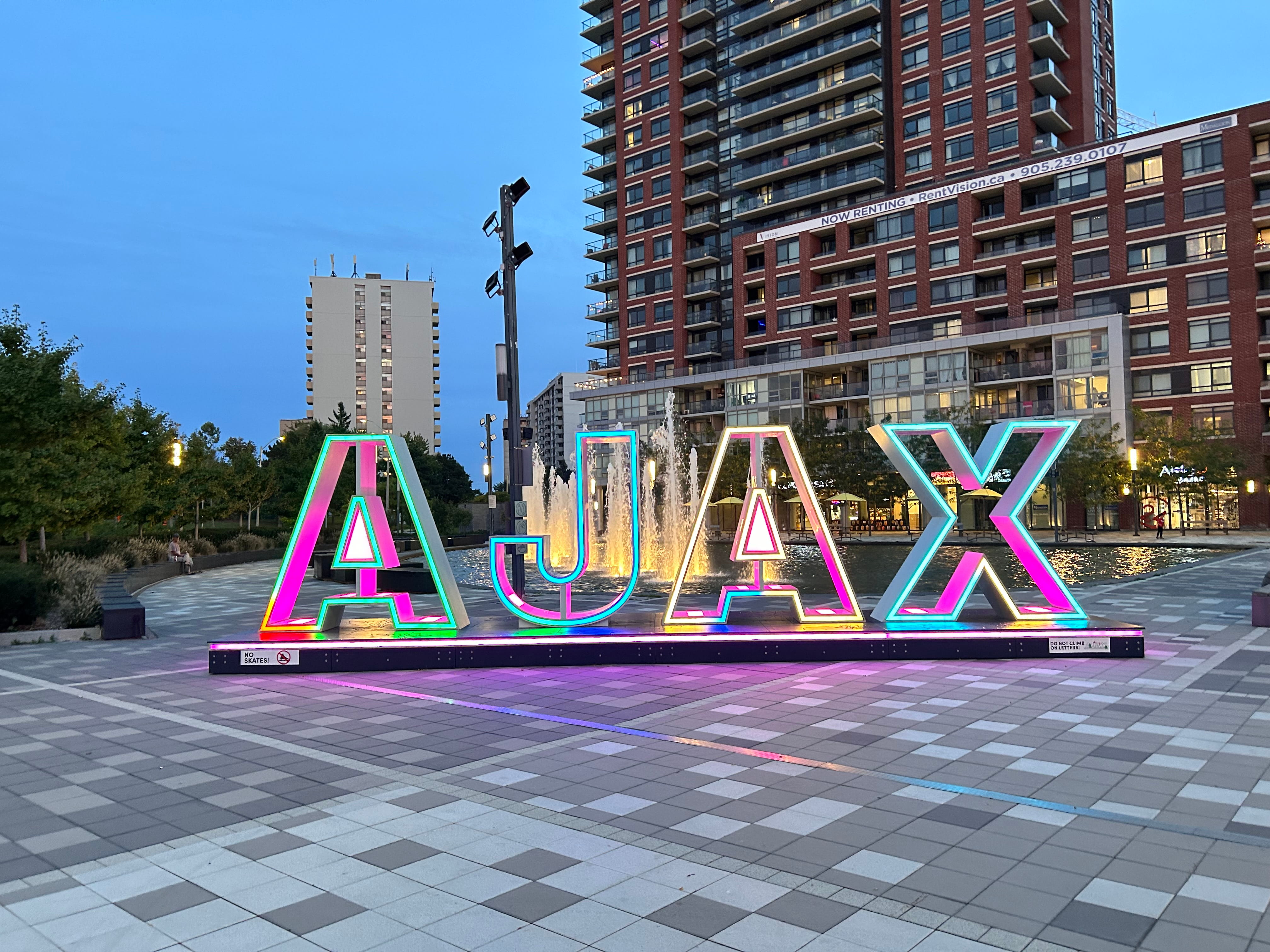 Illuminated Ajax sign at Pat Bayly Square at twilight, representing digital marketing services in Ajax Ontario and the Durham Region